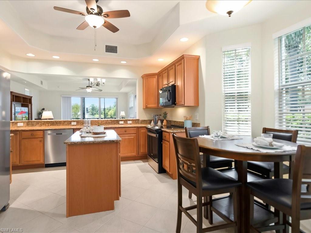 7832 Hawthorne Drive, Unit 1902 Naples, FL 34113 - Photo 12 of 43 a kitchen with stainless steel appliances kitchen island a large island in the center