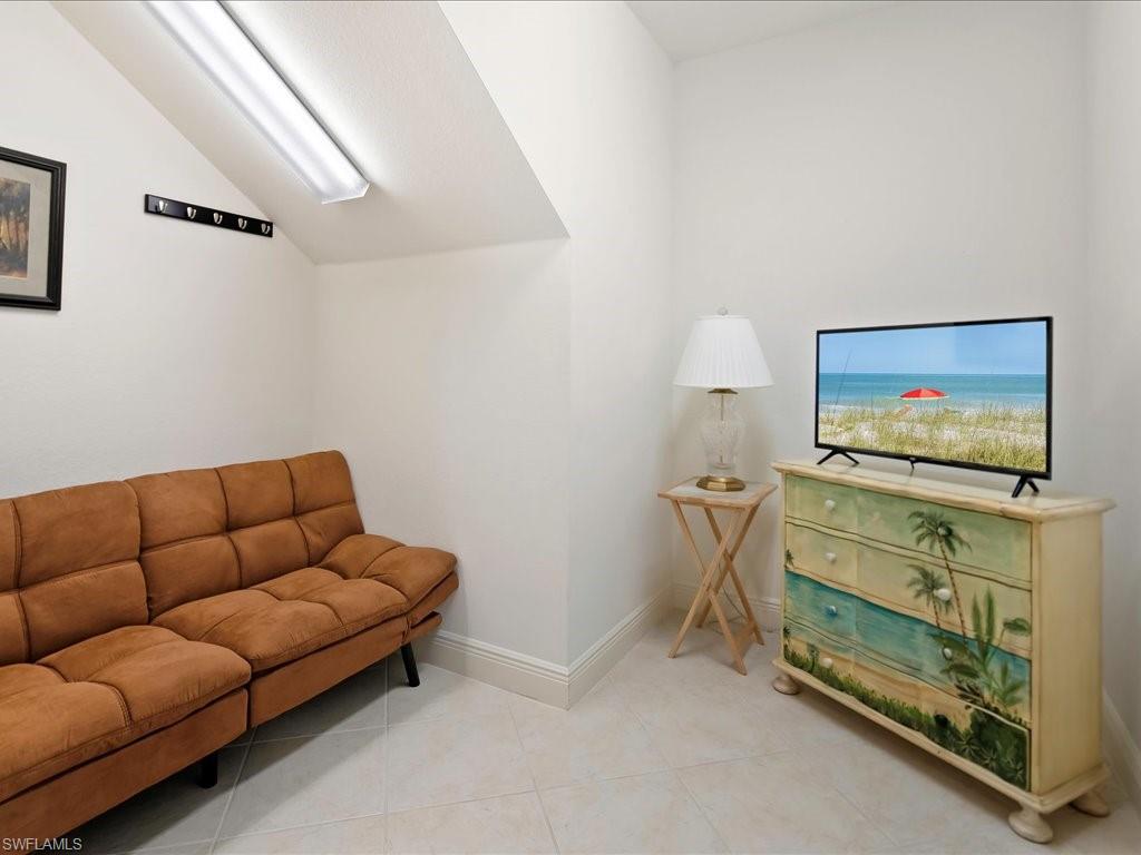 7832 Hawthorne Drive, Unit 1902 Naples, FL 34113 - Photo 24 of 43 a living room with furniture and a flat screen tv