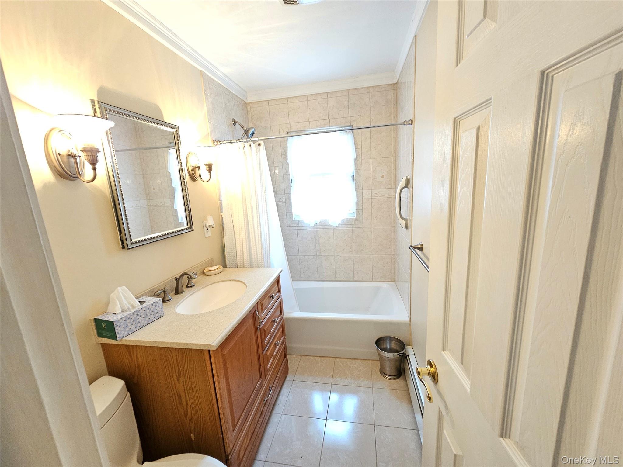 8 Laura Road Monroe, NY 10950 - Photo 5 of 12 Bathroom featuring vanity, crown molding, shower / bathtub combination with curtain, light tile patterned floors, and a baseboard heating unit