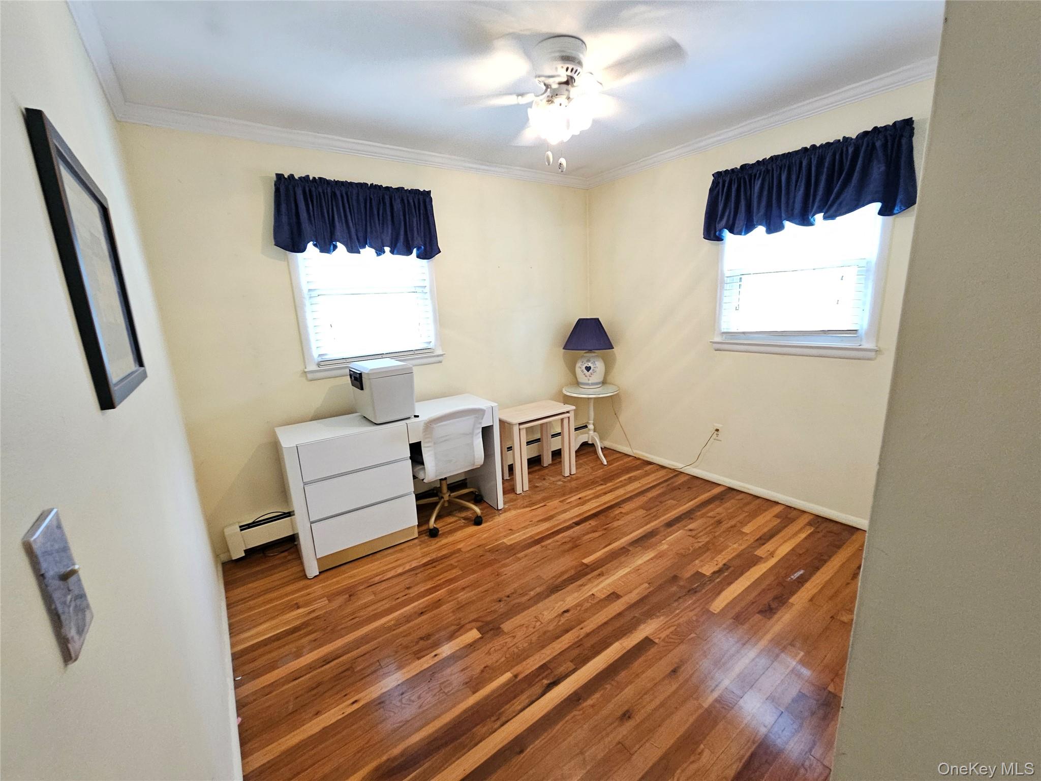 8 Laura Road Monroe, NY 10950 - Photo 6 of 12 Bedroom featuring wood finished floors, healthy amount of natural light, baseboard heating, and crown molding
