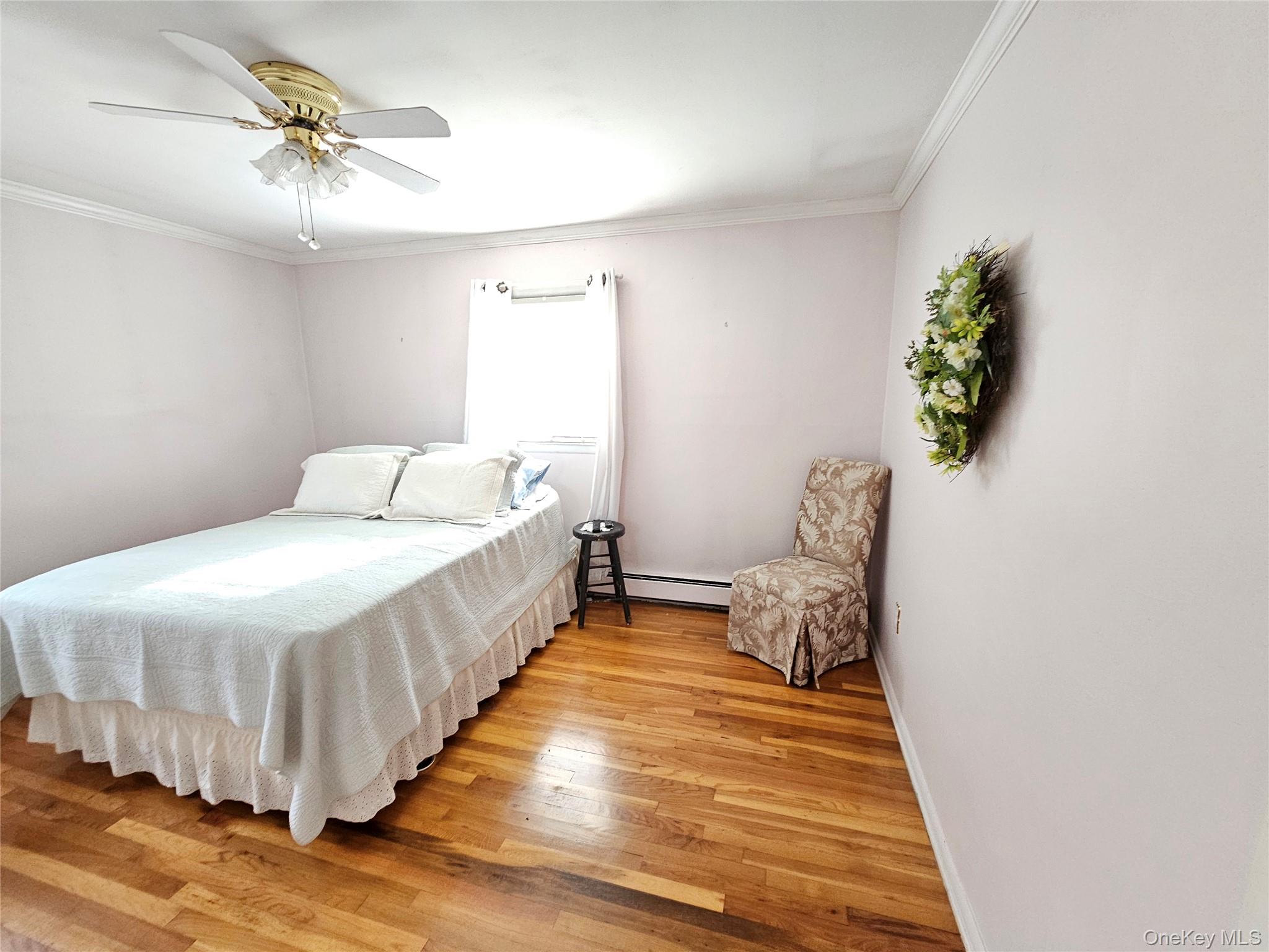 8 Laura Road Monroe, NY 10950 - Photo 7 of 12 Bedroom featuring light wood-style floors, ornamental molding, a ceiling fan, and baseboard heating