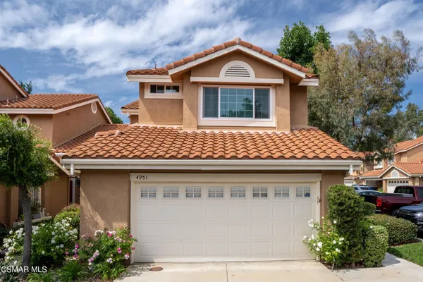 a front view of a house with plants