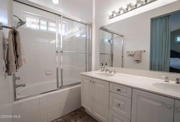 a bathroom with a double vanity sink mirror double and shower
