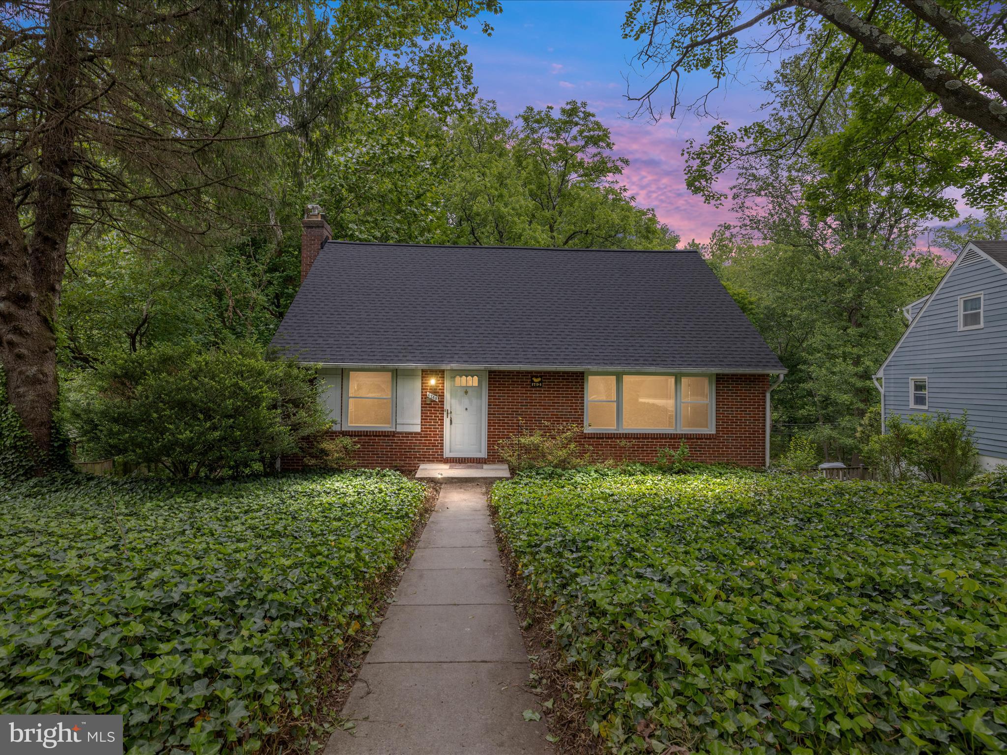 a front view of a house with a yard and trees