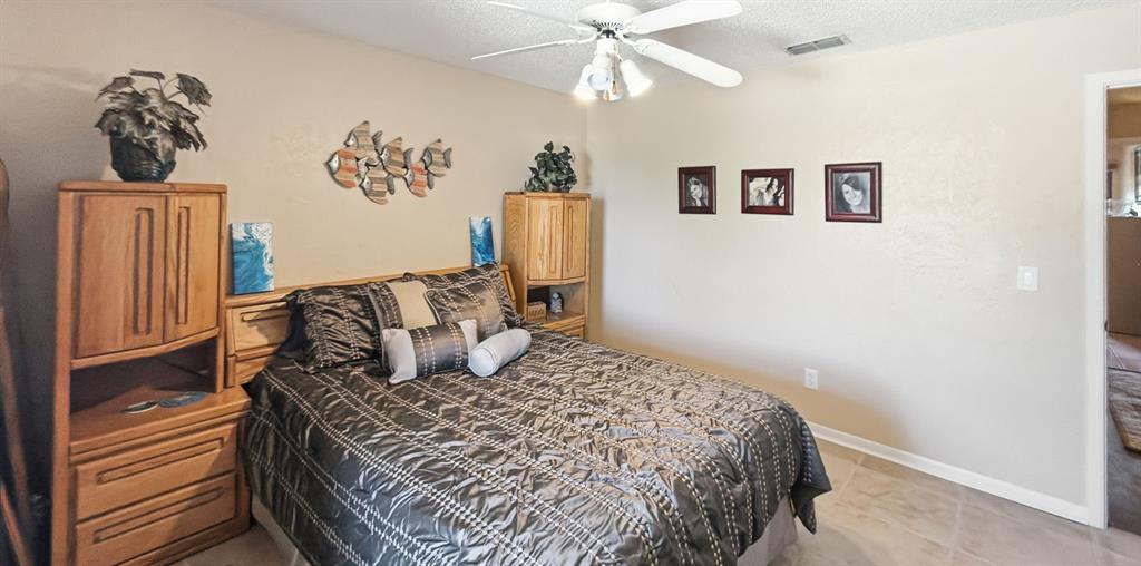 3037 Hells Gate Loop, Unit C208 Strawn, TX 76475 - Photo 19 of 24 a bedroom with a large bed and a chandelier