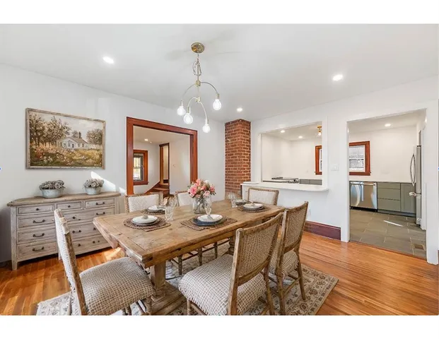 a view of a dining room and livingroom with furniture wooden floor a rug a flat screen tv