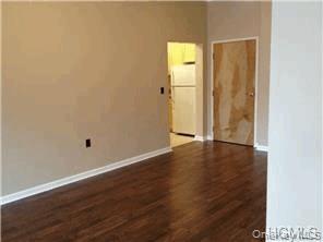 20 South Broadway, Unit 304 Nyack, NY 10960 - Photo 3 of 11 an empty room with wooden floor and windows