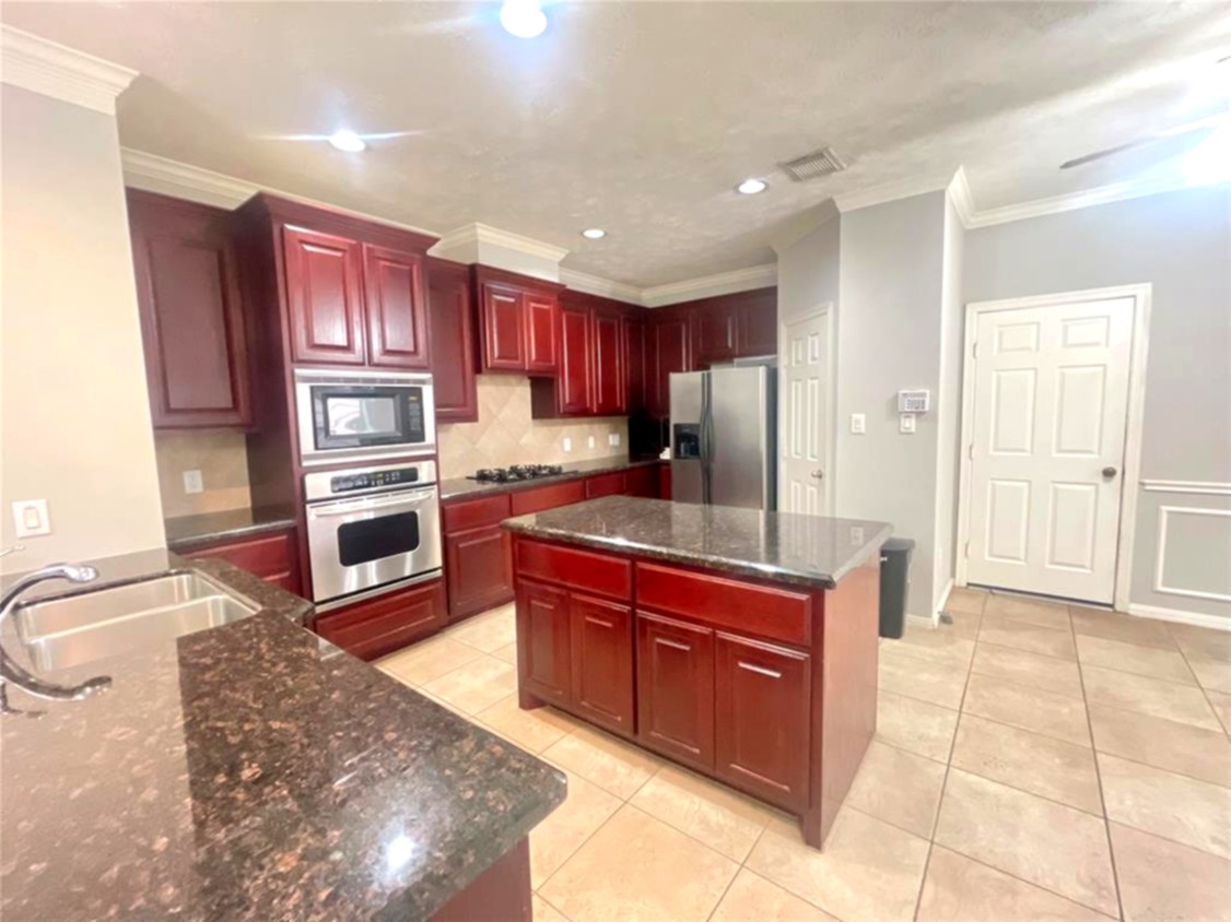 1622 Cohn Street Houston, TX 77007 - Photo 15 of 26 a kitchen with stainless steel appliances granite countertop a stove refrigerator and cabinets