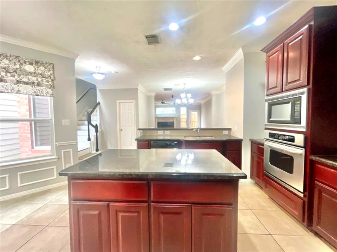 1622 Cohn Street Houston, TX 77007 - Photo 17 of 26 a kitchen with a stove a sink and a wooden cabinets