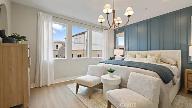 a spacious bedroom with a bed and a chandelier