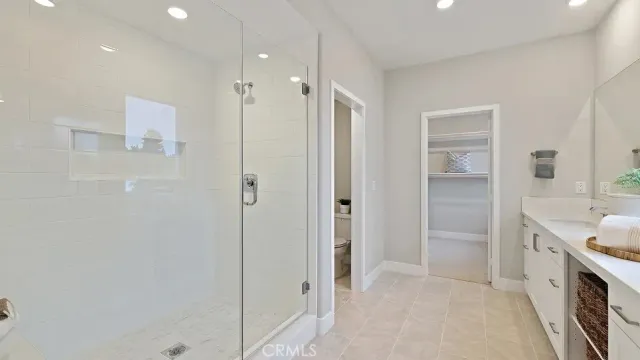 a spacious bathroom with a double vanity sink mirror and shower