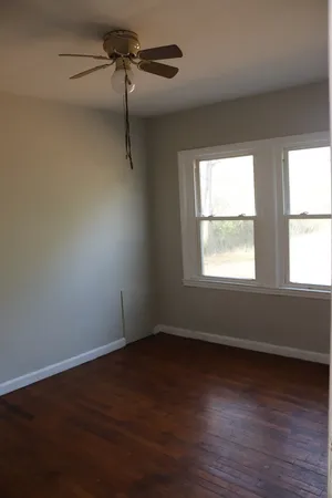 a view of a room with wooden floor and windows