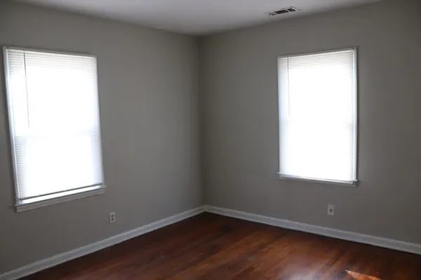 an empty room with wooden floor and a window