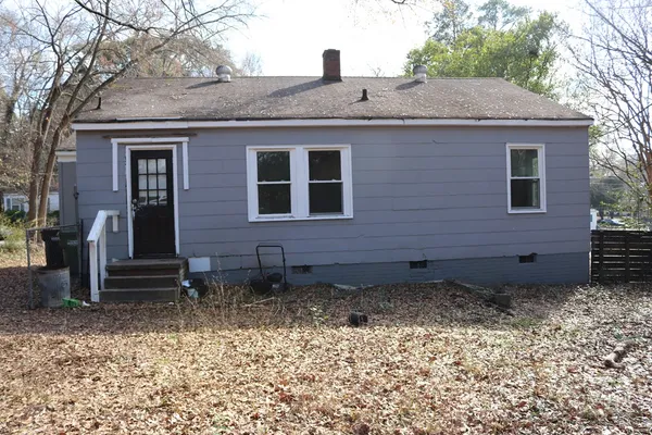 a view of a house with a yard and wooden fence