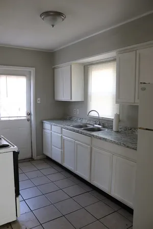 a kitchen with granite countertop a sink and a stove