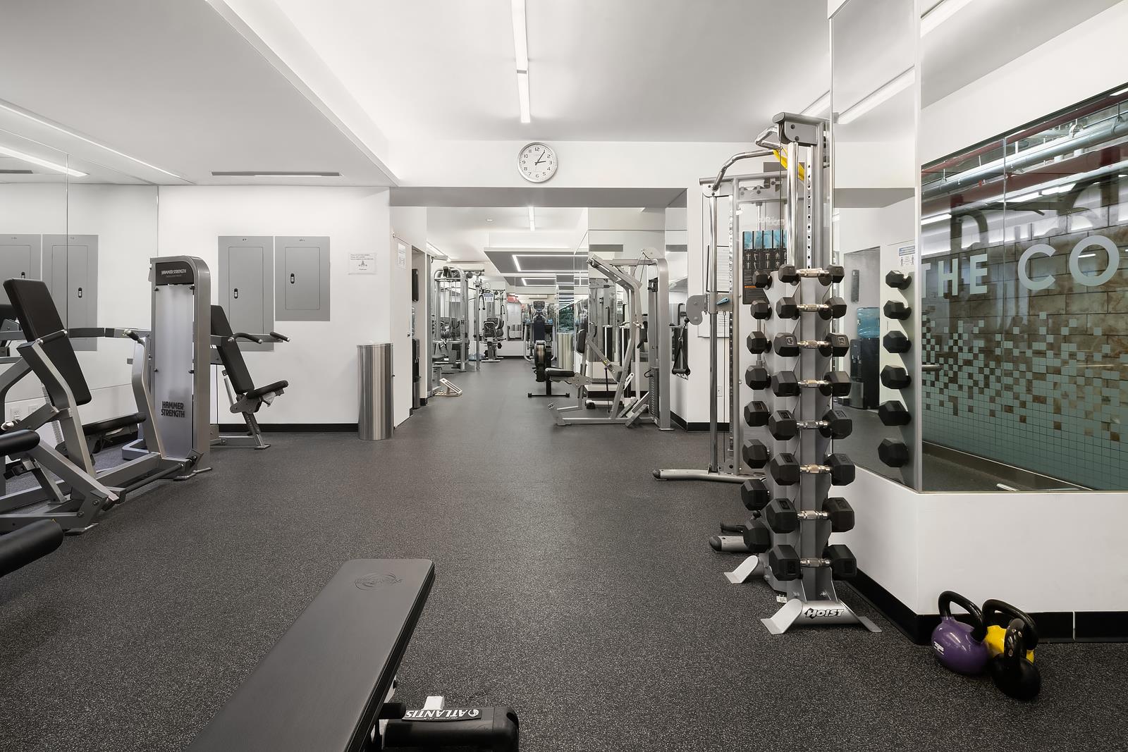 30 West 60th Street, Unit 10S Manhattan, NY 10019 - Photo 14 of 15 a room with gym equipment and large mirror