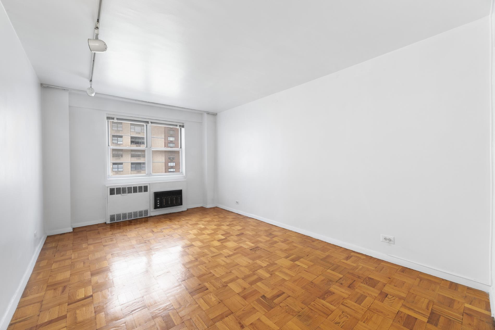 30 West 60th Street, Unit 10S Manhattan, NY 10019 - Photo 5 of 15 an empty room with windows