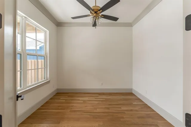 an empty room with windows and fan