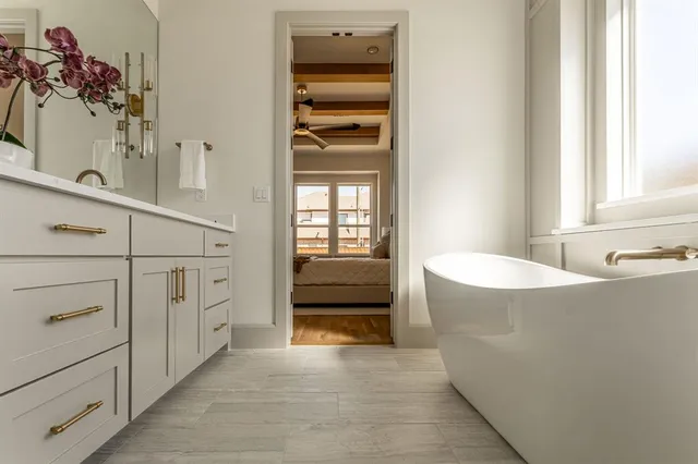 a bathroom with a tub sink and mirror