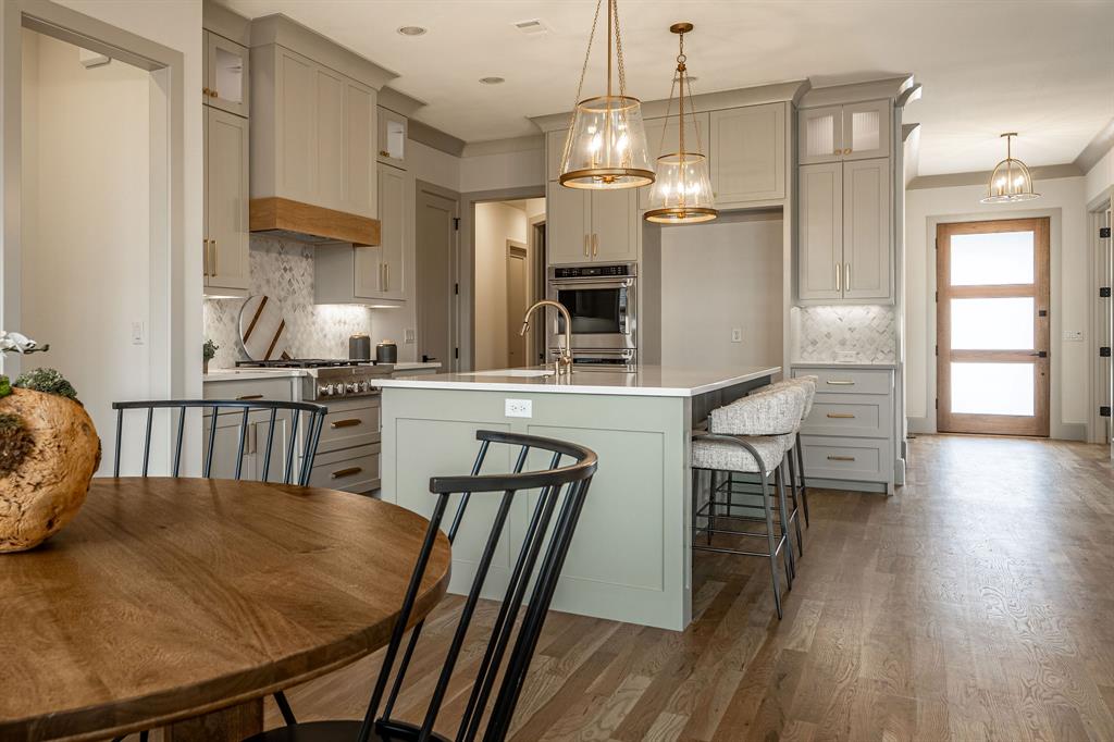 317 Travis Street Roanoke, TX 76262 - Photo 4 of 38 a kitchen with stainless steel appliances granite countertop a dining table chairs stove a refrigerator and a window