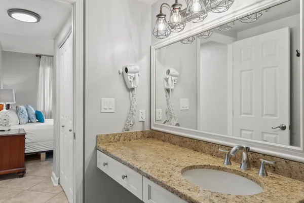 a bathroom with a granite countertop sink a mirror and a shower