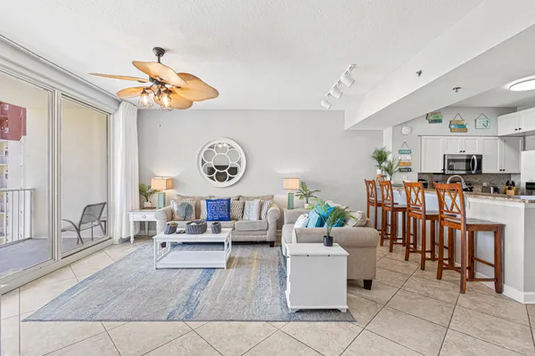 a living room with lots of furniture and view of kitchen