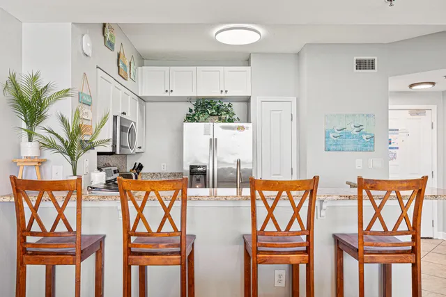 a kitchen with stainless steel appliances wooden floor and a refrigerator