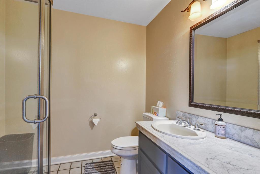 36485 Carney Road Valley Center, CA 92082 - Photo 34 of 75 a bathroom with a granite countertop sink toilet and a mirror