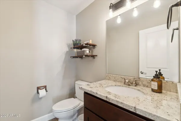 a bathroom with a granite countertop sink a toilet and a mirror