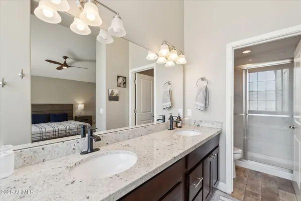 a bathroom with a granite countertop sink a light fixture and a mirror