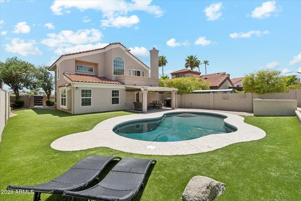 a view of a house with a backyard and swimming pool