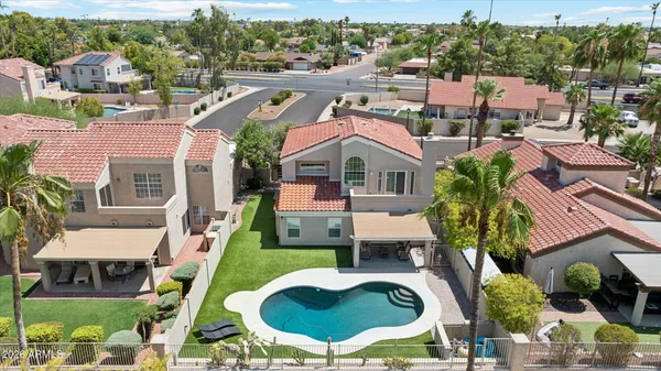 a aerial view of a house with swimming pool and a yard