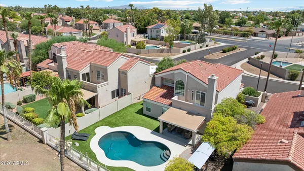 an aerial view of residential houses with outdoor space and parking