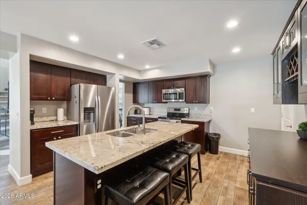 a kitchen with refrigerator and chairs