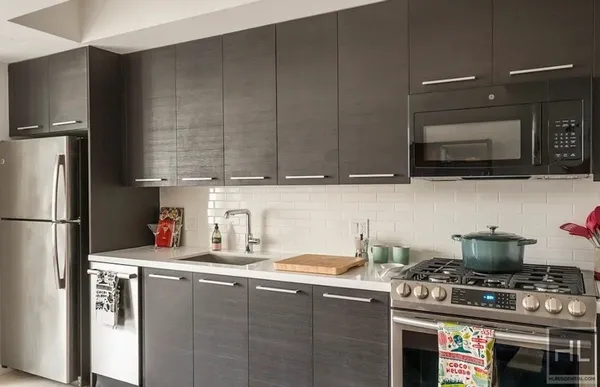 a kitchen with stainless steel appliances granite countertop a stove a refrigerator and a sink