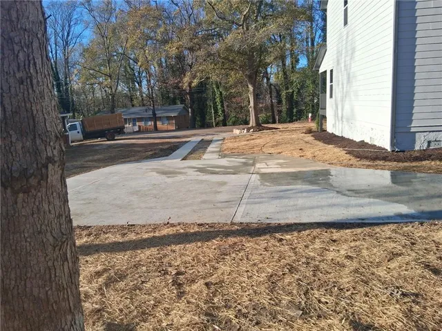 a view of a house with backyard and sitting area