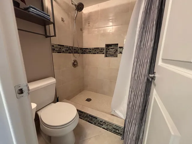 a bathroom with a toilet and a shower