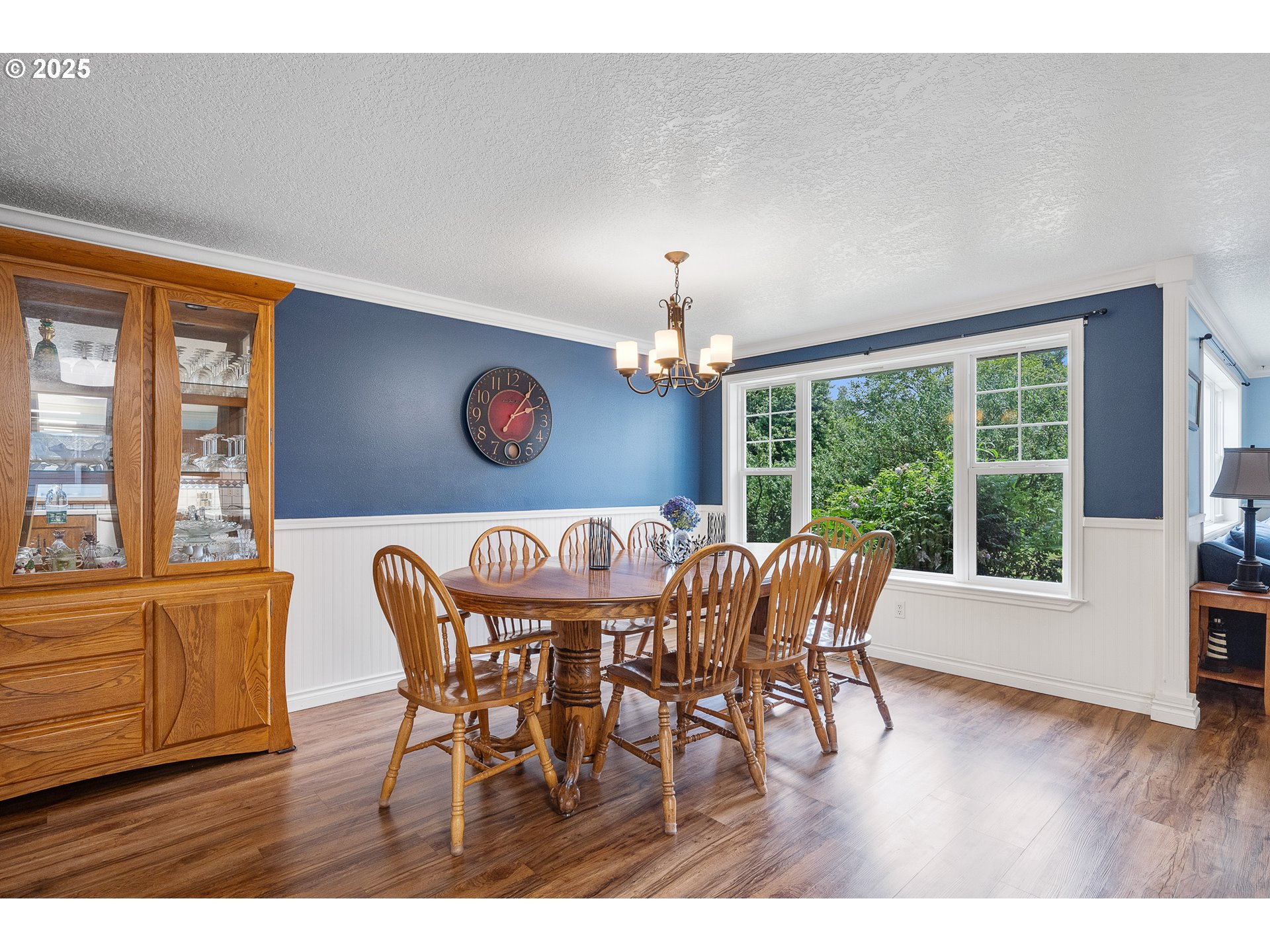 9065 Trask River Road Tillamook, OR 97141 - Photo 6 of 48 a dining room with furniture a chandelier and wooden floor