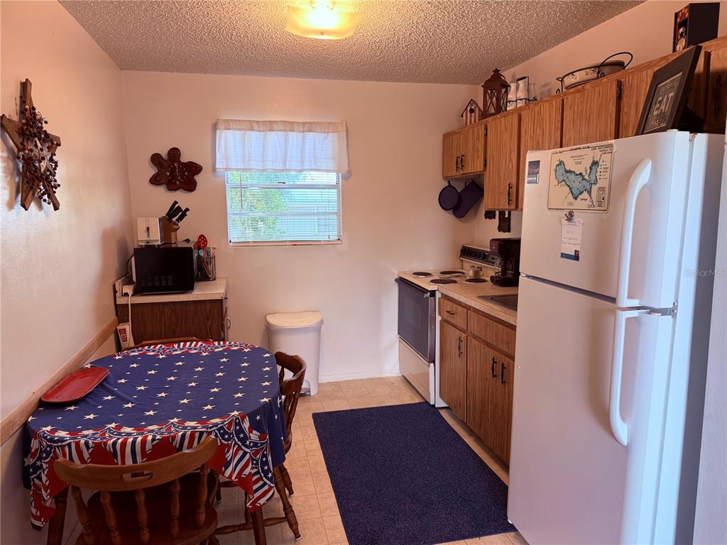 61 Perch Street Haines City, FL 33844 - Photo 58 of 79 a kitchen with stainless steel appliances a stove a refrigerator and a dining table