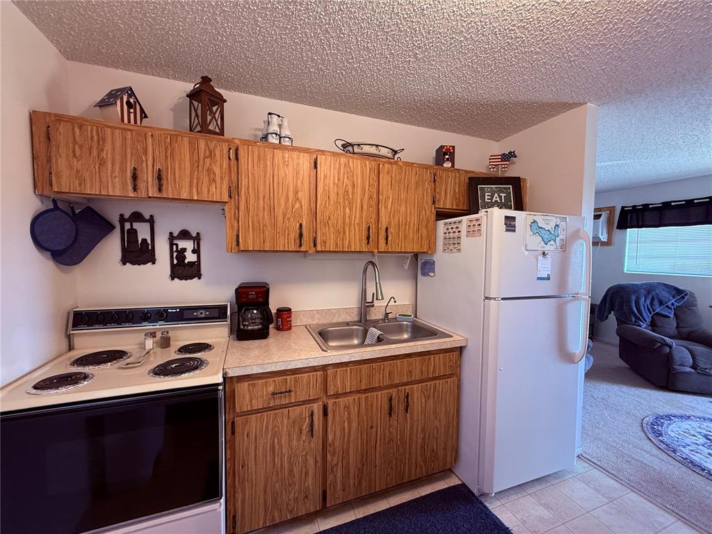 61 Perch Street Haines City, FL 33844 - Photo 59 of 79 a kitchen with a refrigerator a stove a sink and a cabinets
