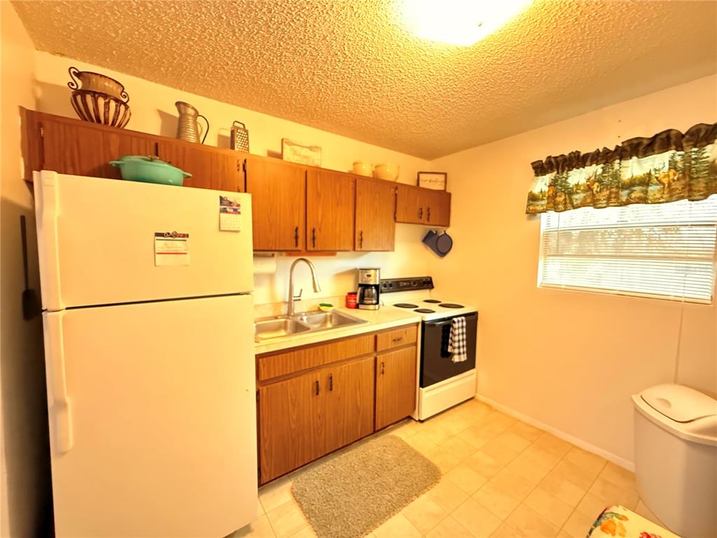 61 Perch Street Haines City, FL 33844 - Photo 65 of 79 a kitchen with a sink a stove and a refrigerator