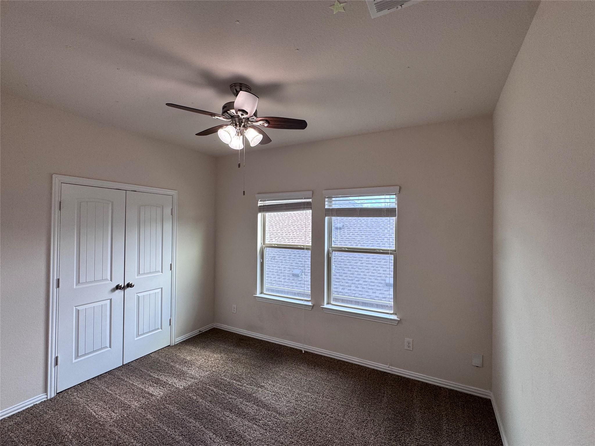2605 Rough Berry Road Pflugerville, TX 78660 - Photo 24 of 40 A well-lit bedroom with ample natural light, featuring comfortable carpet and a ceiling fan for year-round comfort.