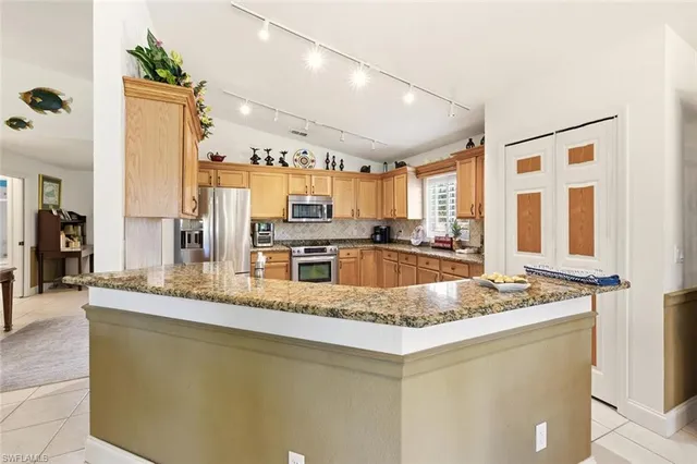 a kitchen with stainless steel appliances granite countertop a sink and a refrigerator