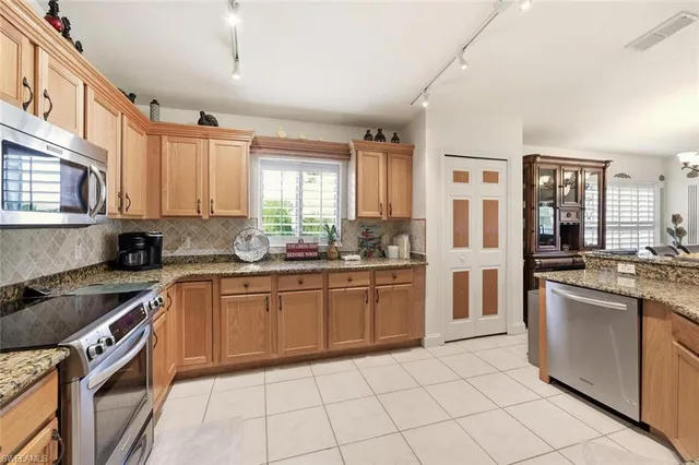 a kitchen with stainless steel appliances granite countertop a stove top oven a sink a counter top space and cabinets