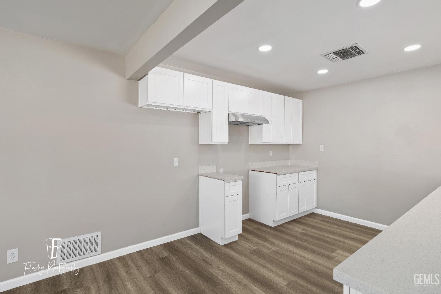 Undisclosed Address Bakersfield, CA 93308 - Photo 13 of 37 a kitchen with granite countertop white cabinets and wooden floor