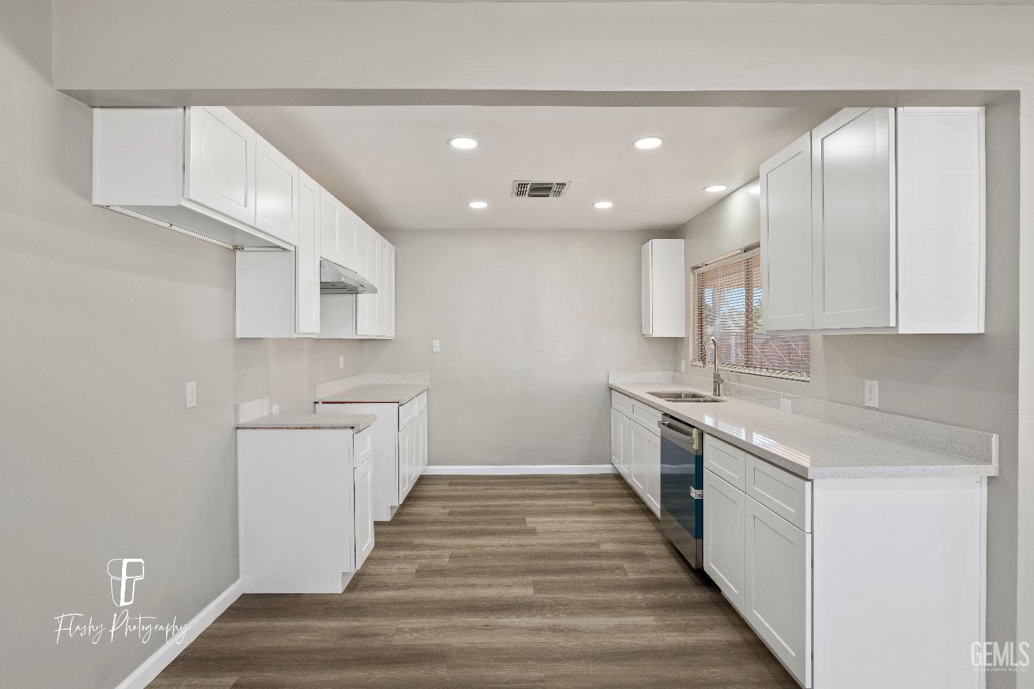 Undisclosed Address Bakersfield, CA 93308 - Photo 14 of 37 a large kitchen with a white stove top oven and white cabinets