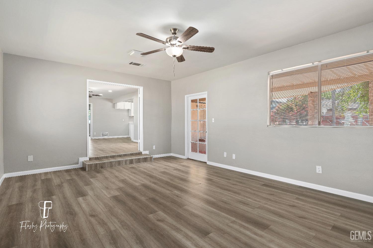 Undisclosed Address Bakersfield, CA 93308 - Photo 19 of 37 a view of an empty room with wooden floor and a window
