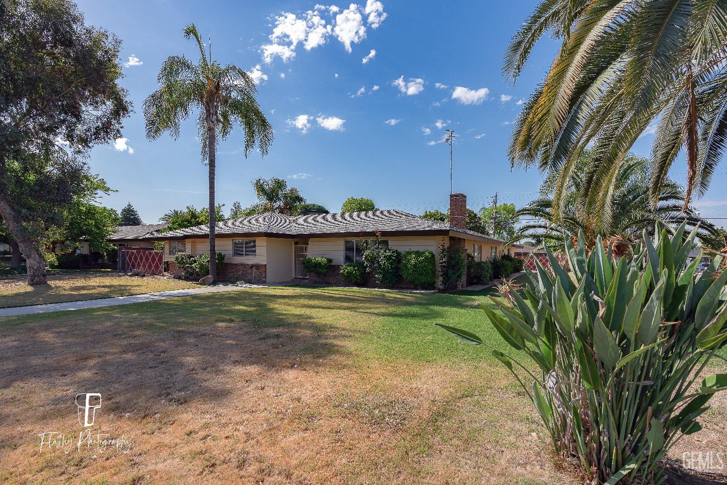 Undisclosed Address Bakersfield, CA 93308 - Photo 2 of 37 a front view of a house with a yard and potted plants