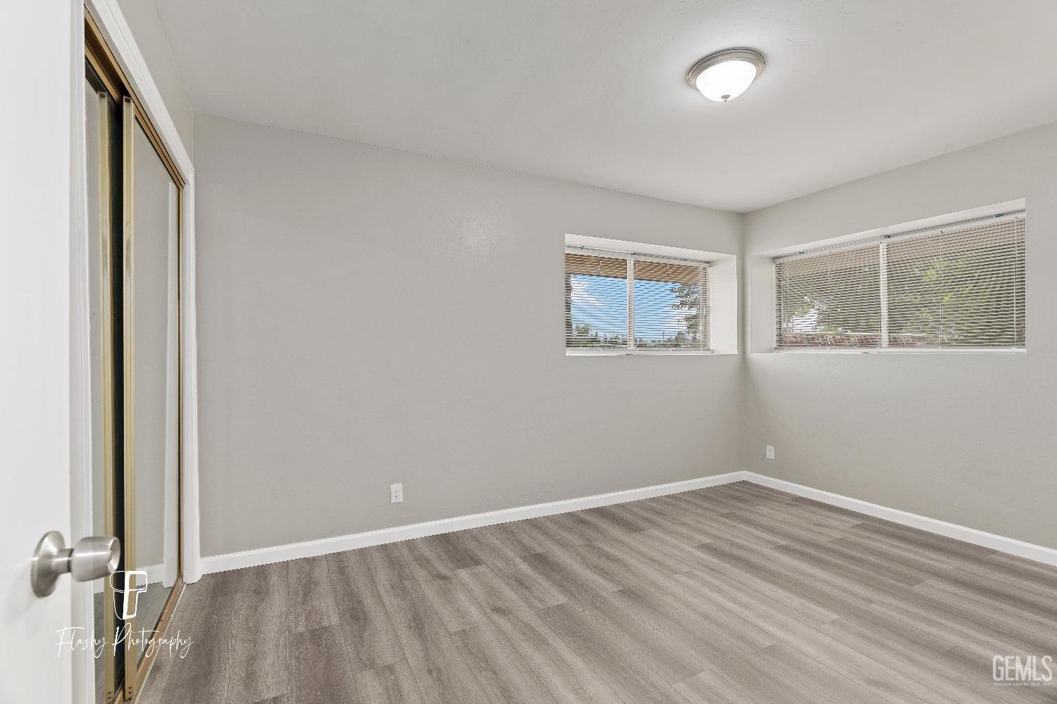 Undisclosed Address Bakersfield, CA 93308 - Photo 23 of 37 an empty room with wooden floor and windows