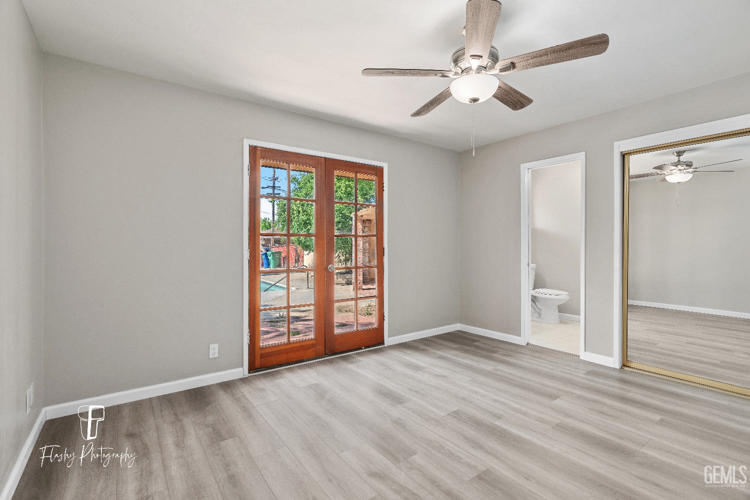 Undisclosed Address Bakersfield, CA 93308 - Photo 25 of 37 an empty room with wooden floor chandelier fan and windows